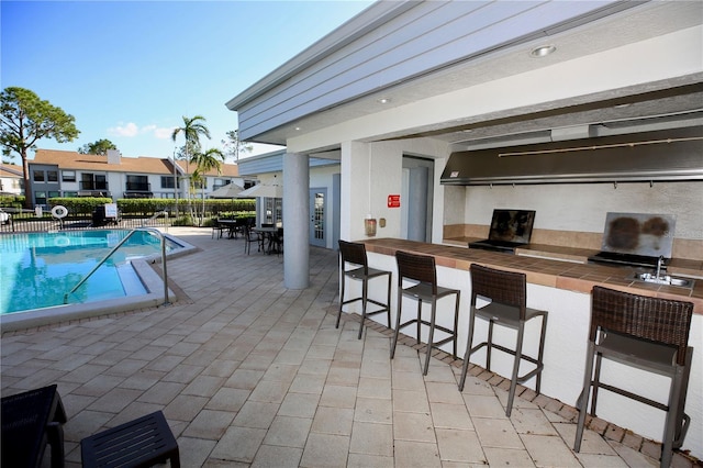 view of pool with a bar and a patio