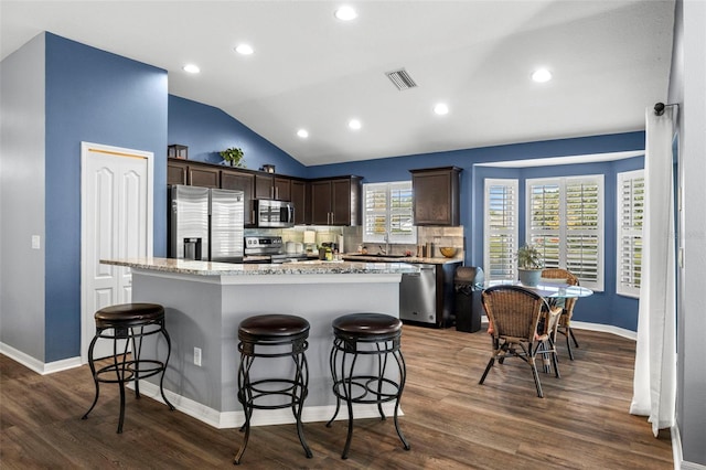 kitchen with a healthy amount of sunlight, stainless steel appliances, and a kitchen island