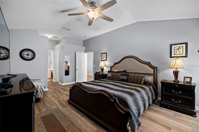 bedroom with connected bathroom, ceiling fan, wood-type flooring, and vaulted ceiling