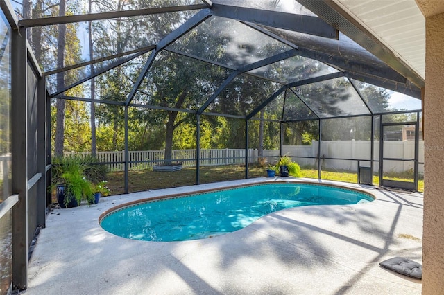 view of pool with a patio area and glass enclosure