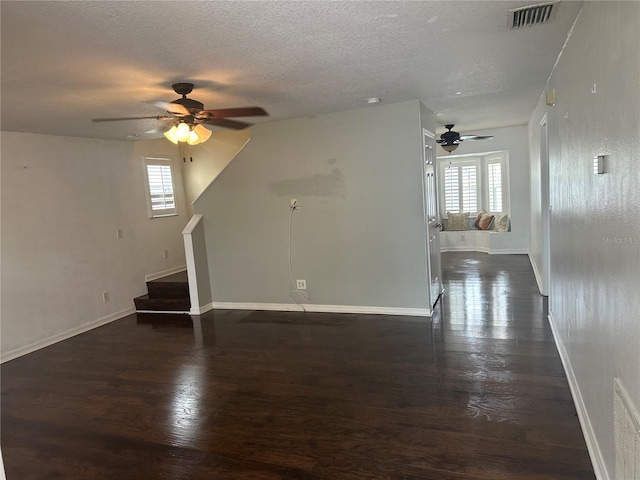 unfurnished living room with a wealth of natural light, dark wood-type flooring, and ceiling fan