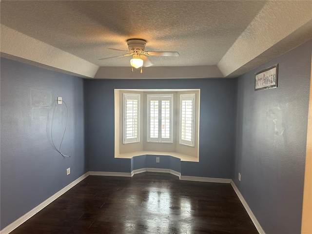 spare room with ceiling fan, dark hardwood / wood-style flooring, and a textured ceiling