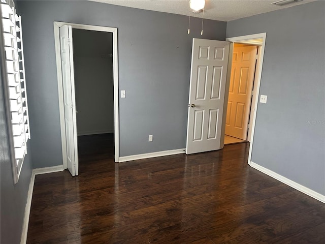 unfurnished bedroom featuring dark hardwood / wood-style flooring and a closet