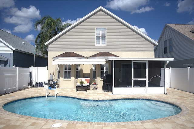 back of house with a patio, a fenced in pool, and a sunroom