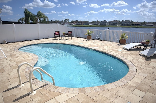 view of swimming pool with a patio and a water view