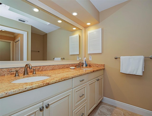 bathroom featuring vanity, a skylight, and tile patterned flooring