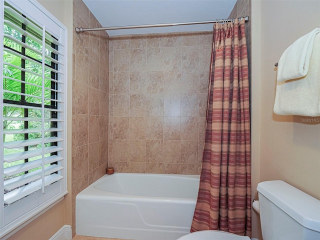 bathroom featuring toilet and shower / tub combo with curtain