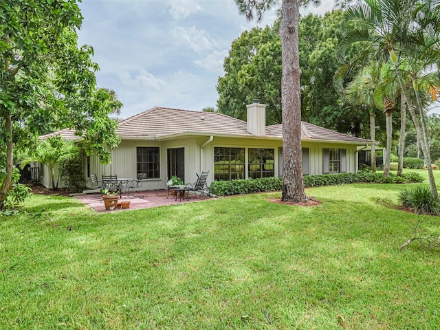 back of house featuring a patio and a lawn