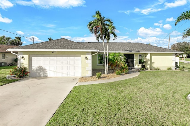 ranch-style home featuring a front yard, cooling unit, and a garage