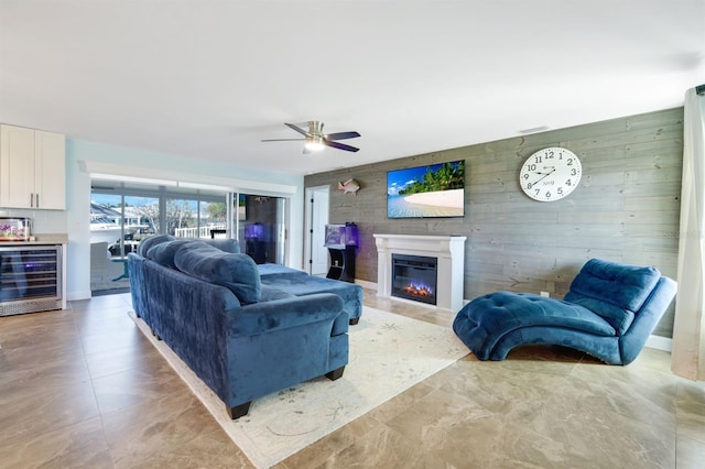 living room with wine cooler, wooden walls, and ceiling fan