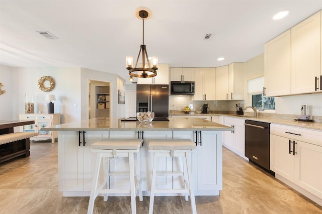 kitchen featuring light stone counters, black appliances, and a kitchen island