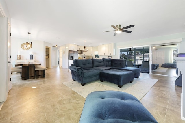 living room featuring ceiling fan with notable chandelier