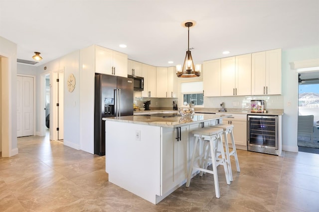 kitchen with stainless steel refrigerator with ice dispenser, a center island, pendant lighting, beverage cooler, and white cabinetry