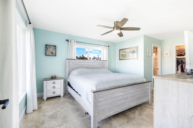 bedroom featuring a spacious closet, ceiling fan, and a closet