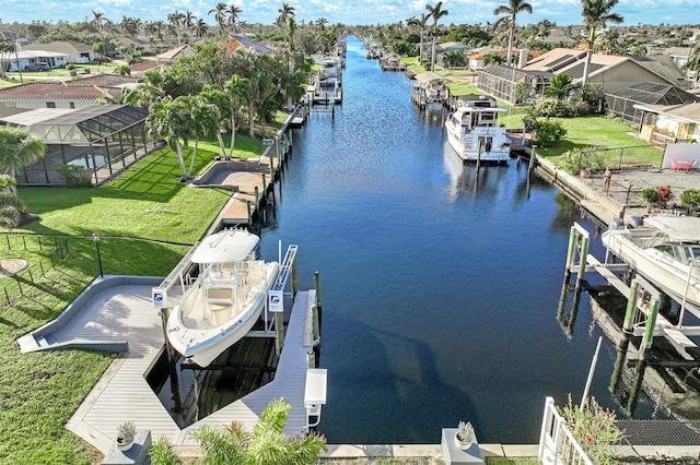 view of dock with a lawn, a water view, and glass enclosure