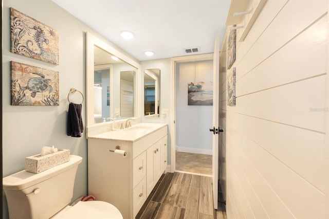 bathroom with vanity, hardwood / wood-style floors, and toilet