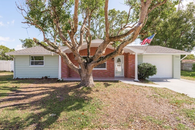 7344 Live Oak Ln, New Port Richey, FL 34653 - ranch-style home with brick siding, an attached garage, concrete driveway, and fence