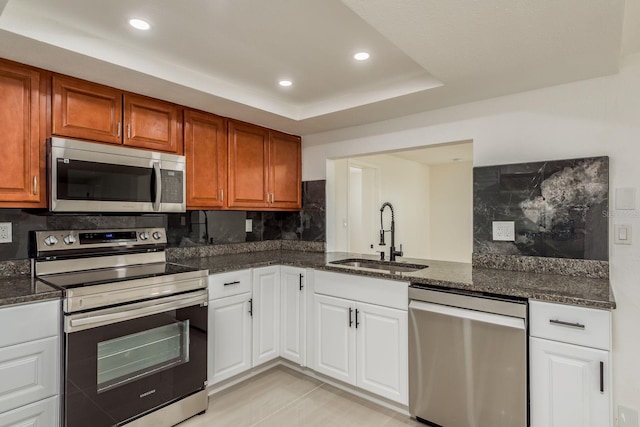 kitchen with sink, decorative backsplash, stainless steel appliances, and white cabinets