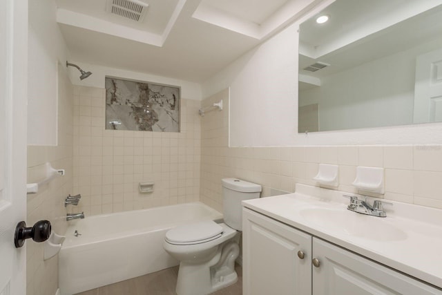 full bathroom with vanity, tiled shower / bath, tile walls, and toilet