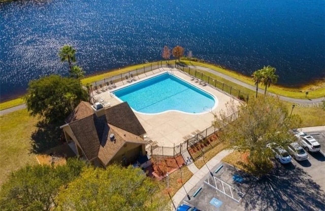 view of swimming pool featuring a patio and a water view