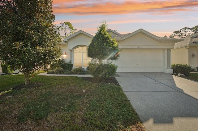 ranch-style home with a yard and a garage