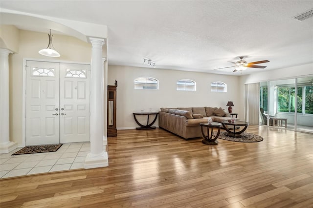 entryway featuring ornate columns, a textured ceiling, ceiling fan, and light hardwood / wood-style floors