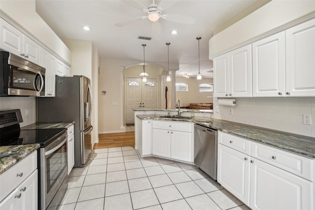 kitchen featuring sink, hanging light fixtures, stainless steel appliances, white cabinets, and kitchen peninsula