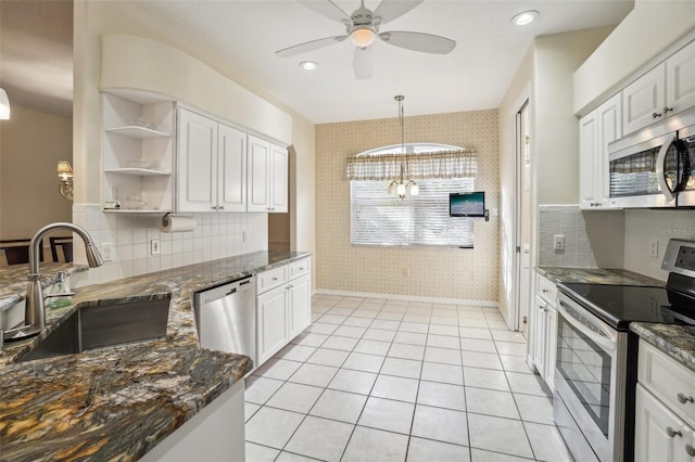 kitchen with sink, appliances with stainless steel finishes, white cabinetry, backsplash, and dark stone countertops