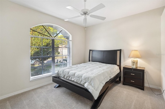 bedroom featuring light carpet, multiple windows, and ceiling fan