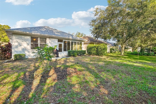 rear view of property featuring a lawn