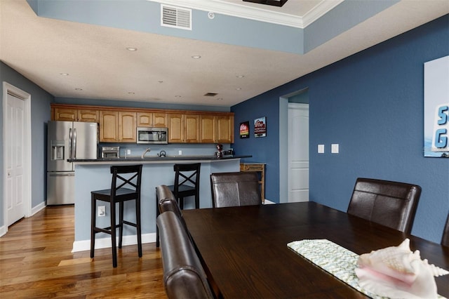 dining room with crown molding and dark hardwood / wood-style flooring