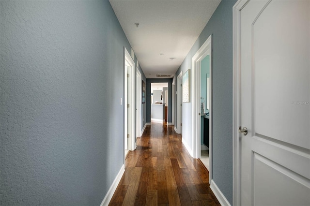 corridor with dark hardwood / wood-style flooring