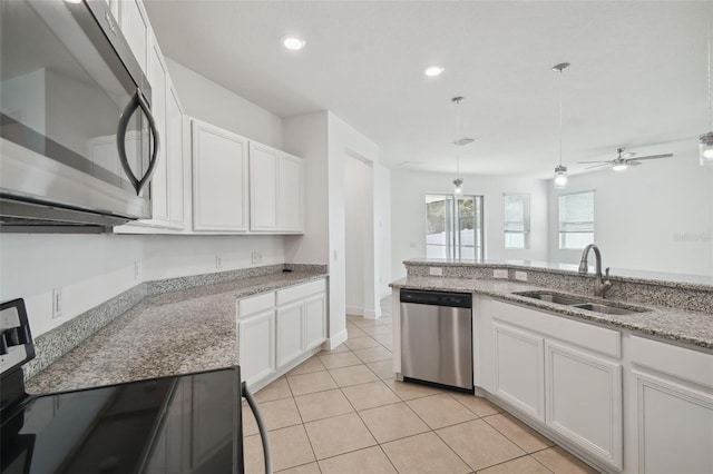 kitchen featuring white cabinetry, sink, light stone counters, and appliances with stainless steel finishes