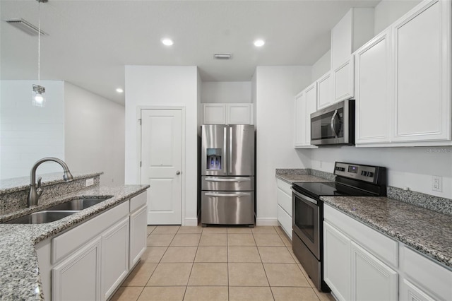 kitchen featuring light stone countertops, white cabinetry, sink, stainless steel appliances, and light tile patterned floors