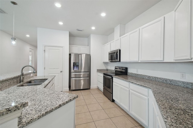 kitchen featuring hanging light fixtures, sink, white cabinets, and stainless steel appliances