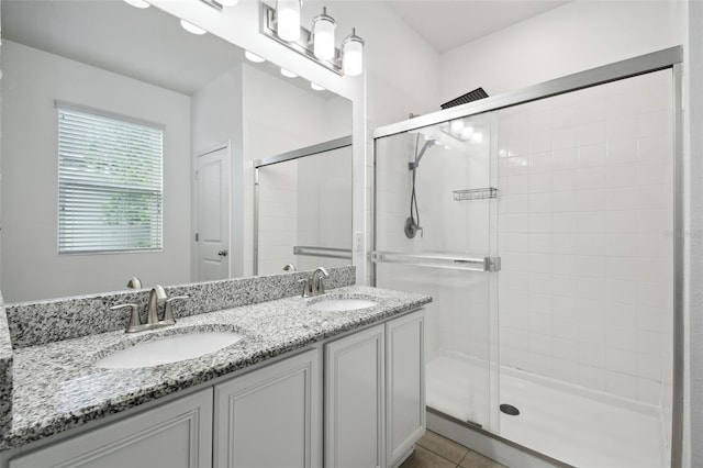 bathroom featuring tile patterned flooring, vanity, and walk in shower