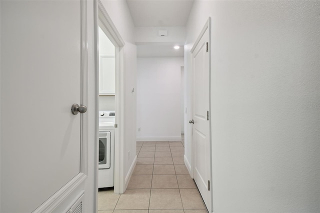 hall with washer / dryer and light tile patterned floors