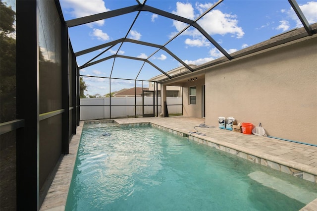 view of pool with glass enclosure and a patio