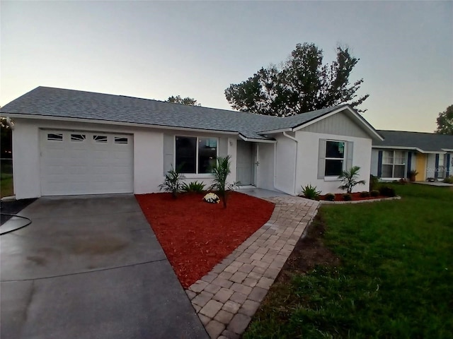 ranch-style house featuring a garage and a yard