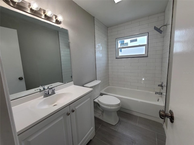 full bathroom featuring toilet, vanity, tiled shower / bath, and tile patterned floors