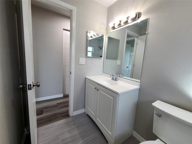 bathroom with hardwood / wood-style floors, vanity, and toilet