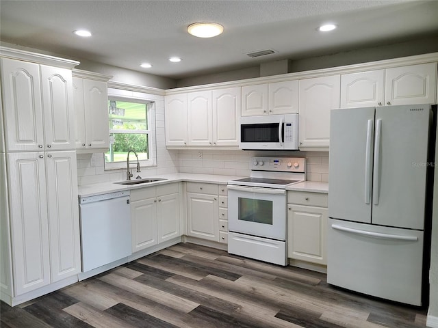 kitchen featuring white cabinets, decorative backsplash, sink, dark hardwood / wood-style floors, and white appliances