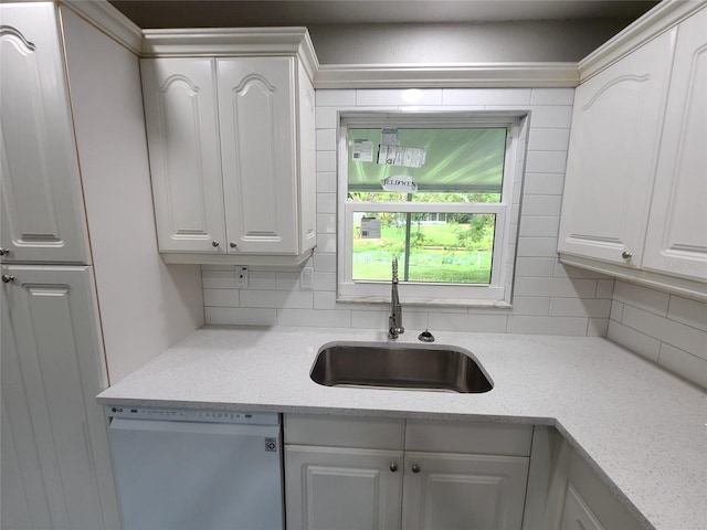 kitchen with dishwasher, tasteful backsplash, white cabinetry, and sink