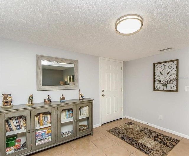 tiled foyer with a textured ceiling