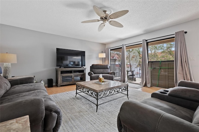 living room with a textured ceiling and ceiling fan