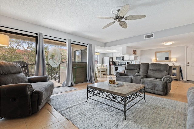 tiled living room featuring a textured ceiling and ceiling fan