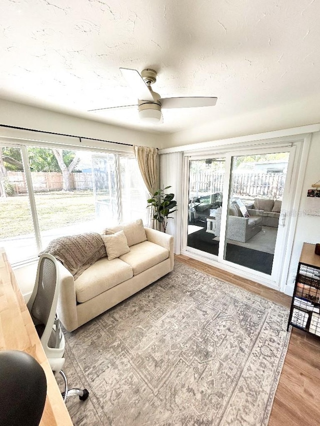 living room featuring wood-type flooring and ceiling fan