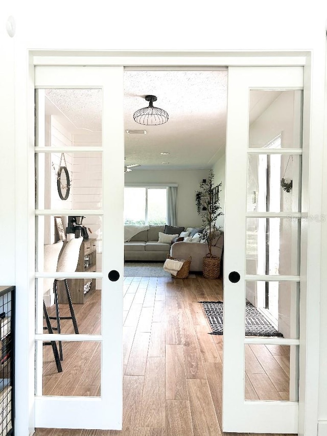 doorway featuring french doors, hardwood / wood-style flooring, and a textured ceiling