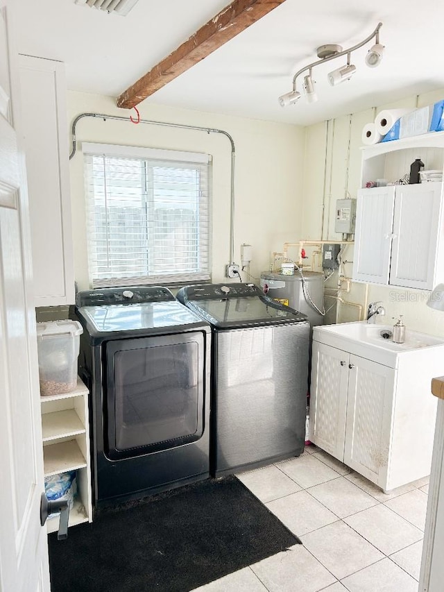 washroom with independent washer and dryer, light tile patterned floors, and cabinets