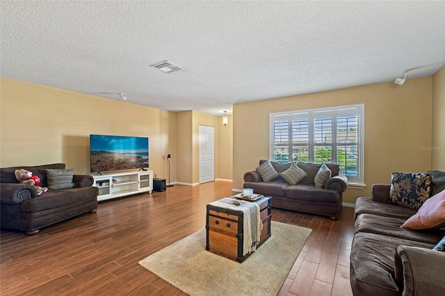 living room with dark hardwood / wood-style floors and a textured ceiling